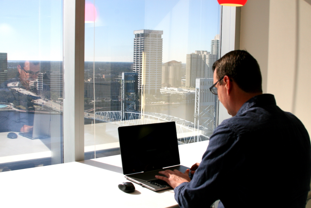 An online student sitting at his laptop at JU's Downtown location.